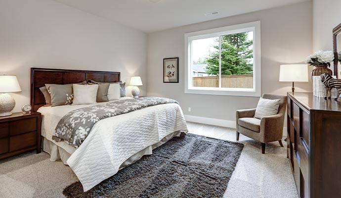A master bedroom featuring freshly painted light gray walls