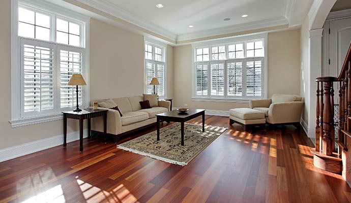 A bright living room with polished hardwood floors, showcasing the results of a professional flooring partnership and complete floor services.
