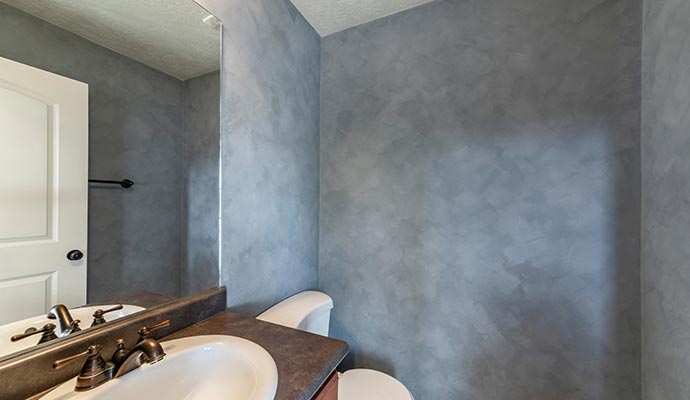 A bathroom interior featuring a vanity with a white sink and brass faucet