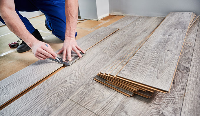 A professional flooring installer fitting wood planks