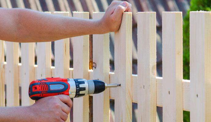 Expert installing beautifully painted fence