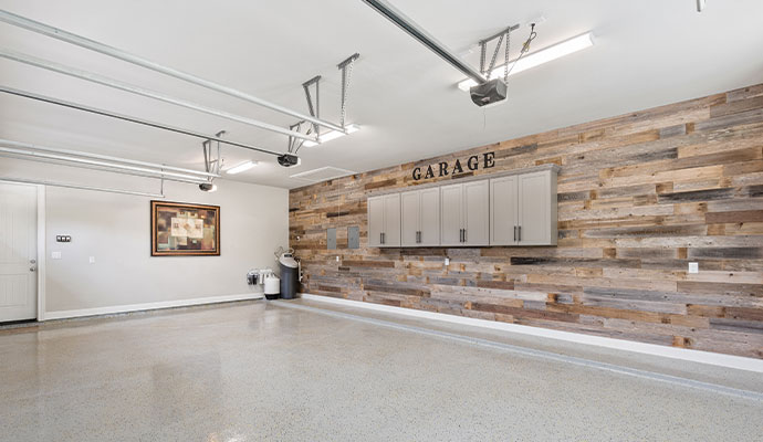 A high-end garage with a reclaimed wood accent wall.