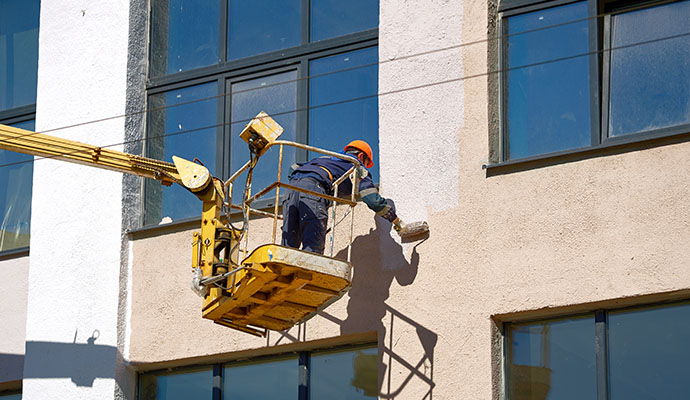 professional worker painting a commercial building