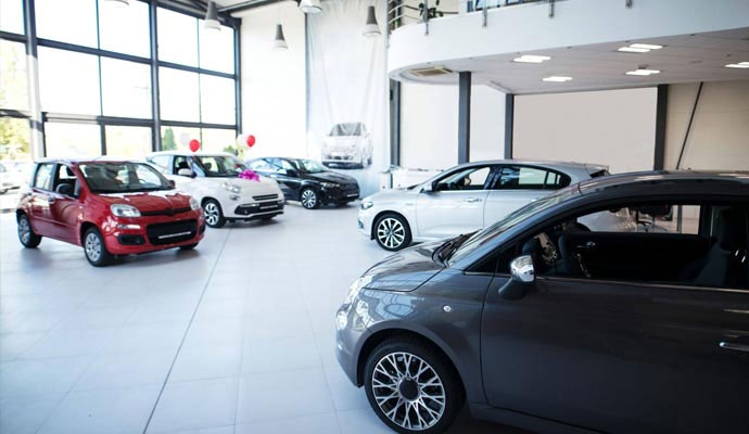 A bright car showroom with professional interior painting, high ceilings, and polished floors.