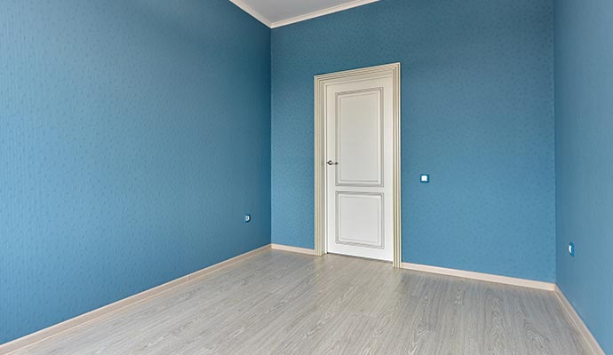 Empty room with blue walls and a white door Empty room with blue walls and a white door