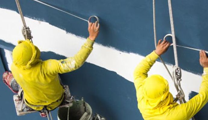 Professional painting service of commercial building exterior Professional painters applying exterior paint on a commercial building with precision and quality finish