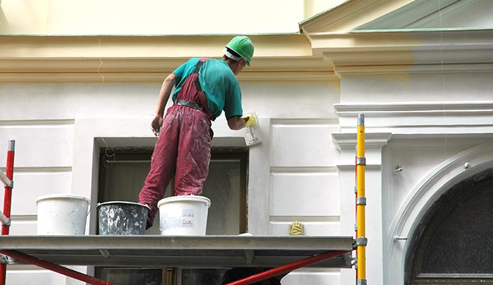 Skilled painter working on home exterior painting project, enhancing curb appeal.