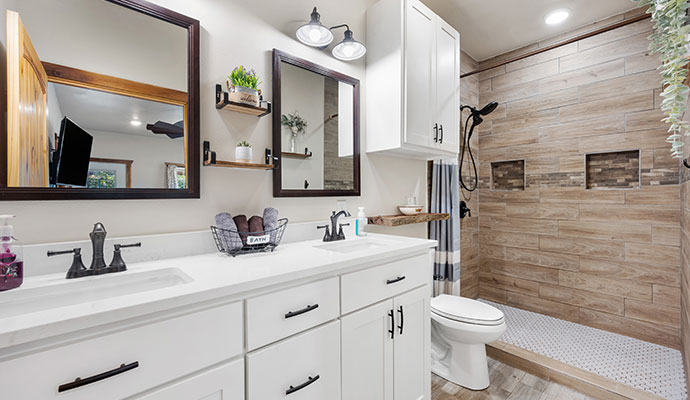 A modern bathroom with a double vanity and a walk-in shower.