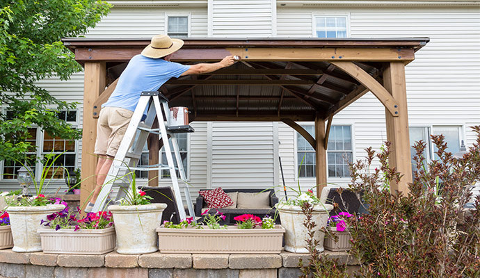 worker painting outdoor shelter