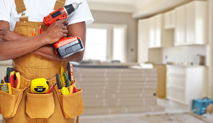Professional handyman and renovation services A handyman with a tool belt and a power drill.