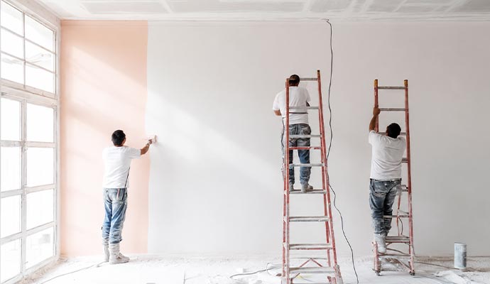 Professional painting crew members applying paint to an interior wall