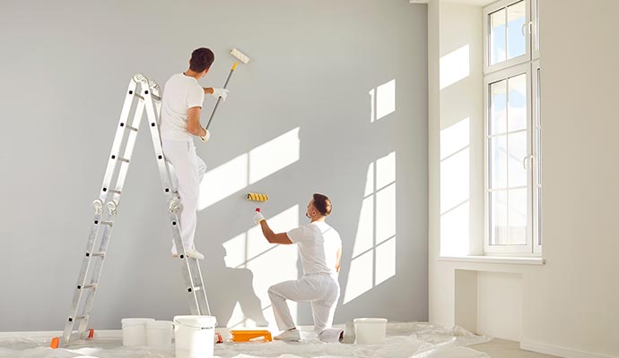 Workers painting the walls of a store room, improving its appearance.